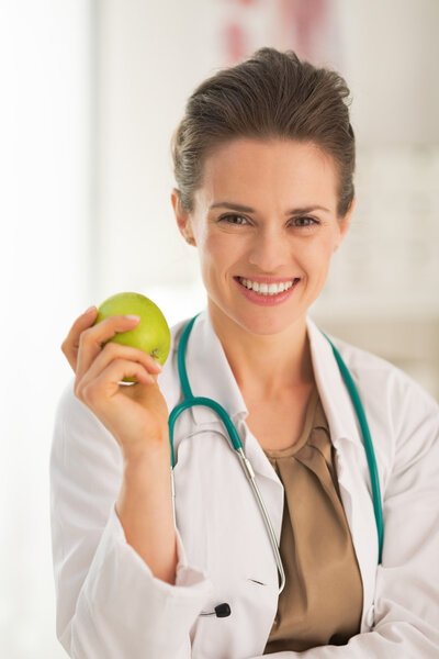 Портрет улыбающейся докторши с яблоком
