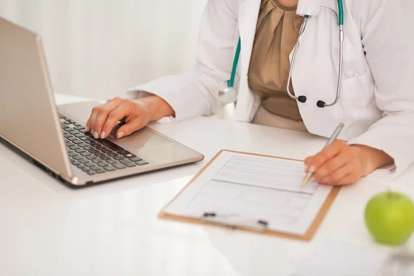 Closeup on doctor woman working on laptop in office — Stock Photo, Image