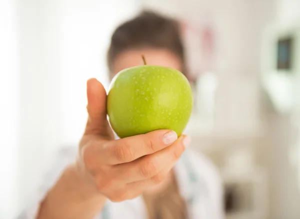 Gros plan sur médecin femme montrant pomme devant le visage — Photo