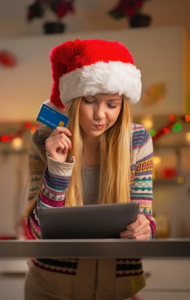 Portrait of thoughtful teenager girl in santa hat with credit ca — Stock Photo, Image