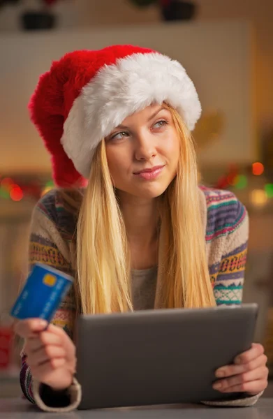 Portret van doordachte tiener meisje in Kerstman hoed met credit ca — Stockfoto