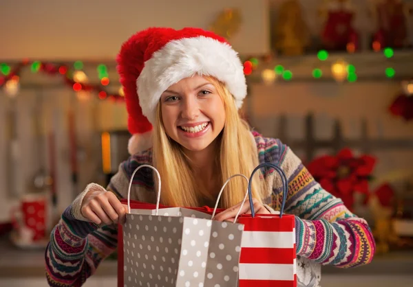 Retrato de adolescente feliz en sombrero de santa con bolsas de compras —  Fotos de Stock