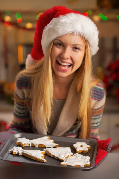 Portrait of happy teenager girl in santa hat showing pan of fres — Stock Photo, Image