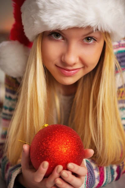 Retrato de menina adolescente em santa chapéu segurando bola de Natal — Fotografia de Stock