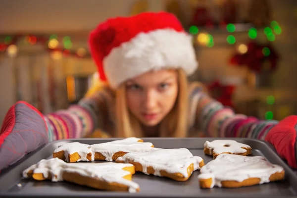 Closeup on teenager girl in santa hat pulling out pan of fresh c — Stock Photo, Image