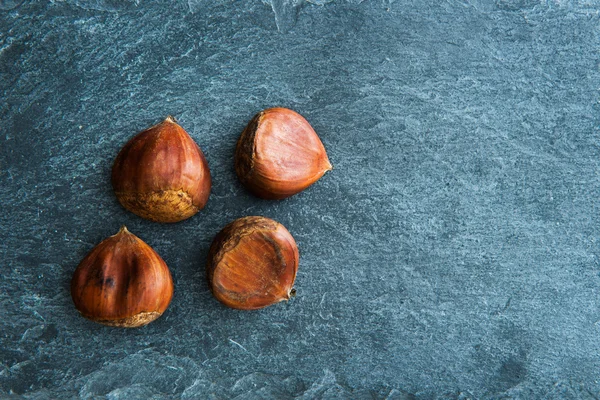 Closeup on chestnuts on stone substrate — Stock Photo, Image