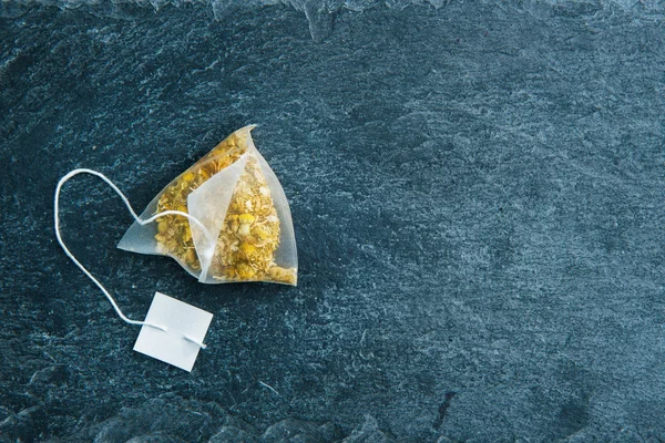 Closeup on camomile tea bag on stone substrate — Stock Photo, Image