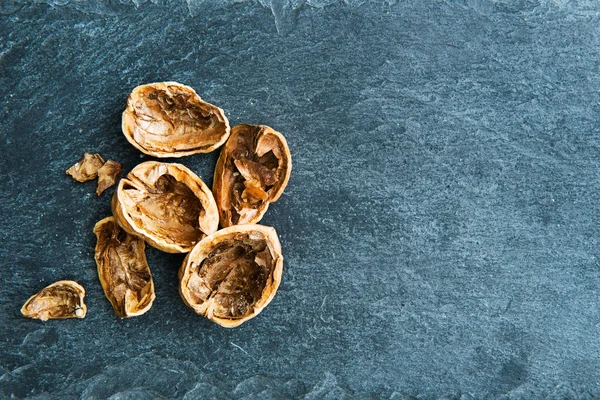 Closeup on walnut shells on stone substrate — Stock Photo, Image