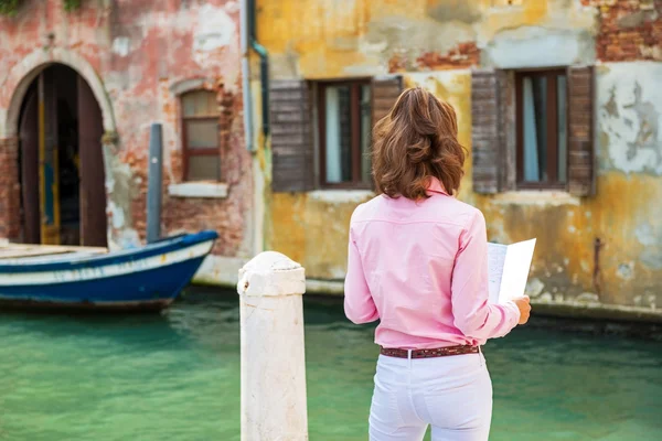 Young woman in venice, italy looking at map. rear view — Stock Photo, Image