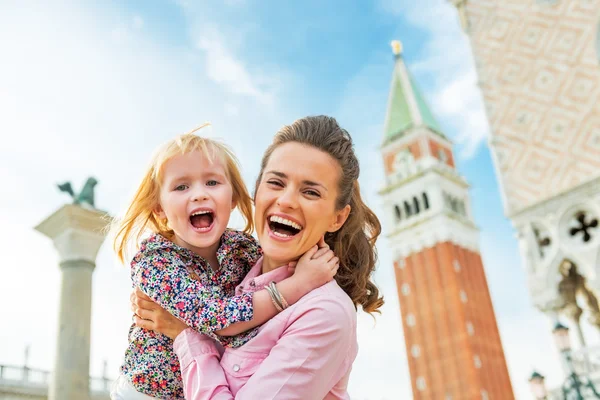 Portret van gelukkige moeder en baby tegen campanile di san marco — Stockfoto