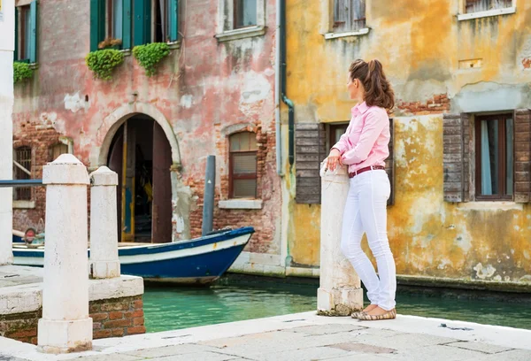 Молодая женщина, стоящая на улице в Venice, Италия и глядя в — стоковое фото