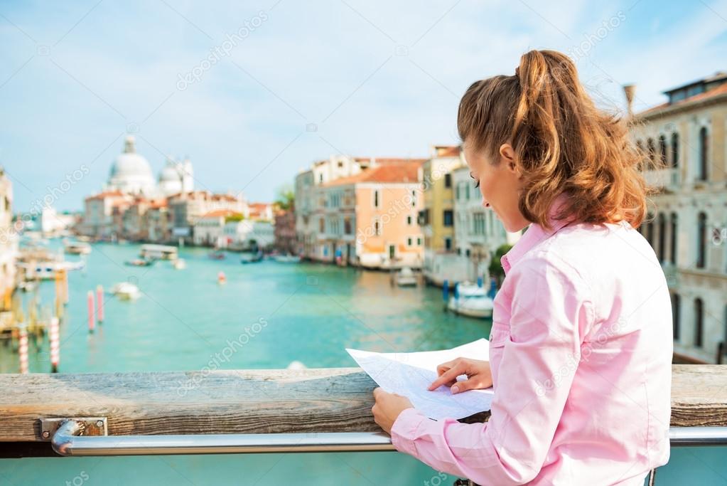 Young woman standing on bridge with grand canal view in venice,