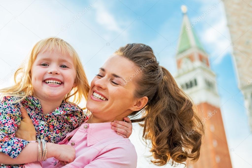 Portrait of happy mother and baby against campanile di san marco