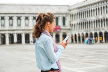 Genç kadın SMS yazma piazza san marco Venedik, İtalya. Re