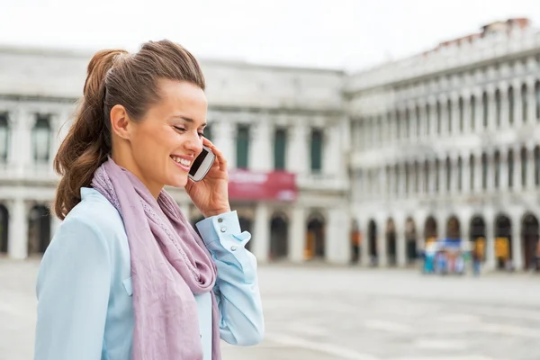 Porträtt av glad ung kvinna talande mobiltelefon på piazza san m — Stockfoto