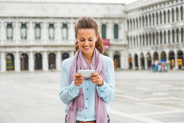 Glad ung kvinna skriver sms på piazza san marco i Venedig, ita — Stockfoto