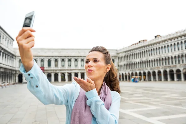Joven mujer soplando beso y haciendo selfie en piazza san marco i —  Fotos de Stock