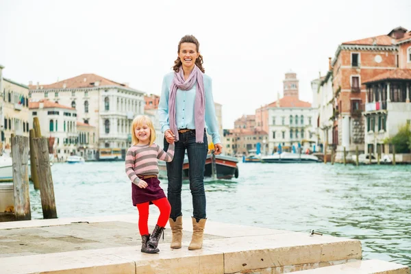 Mor og baby pige stående på dæmning i venice, kursiv - Stock-foto