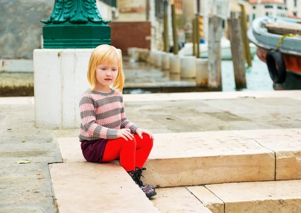 Baby girl sitting on embankment in venice, italy — Stock Photo, Image