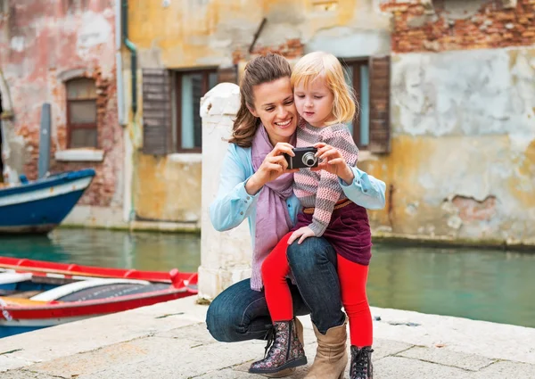 Happy mother and baby girl checking photos in camera while in ve — Stock Photo, Image