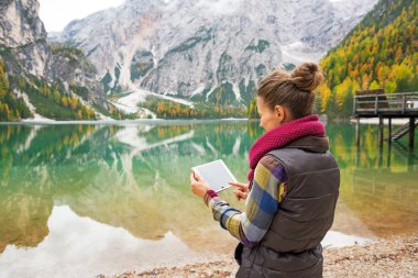 Göl braies iken Güney Tyrol'deki / daki Tablet PC'de kullanan genç kadın,