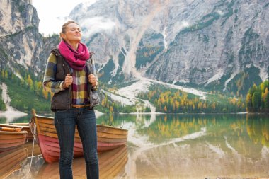 Relaxed young woman on lake braies in south tyrol, italy clipart
