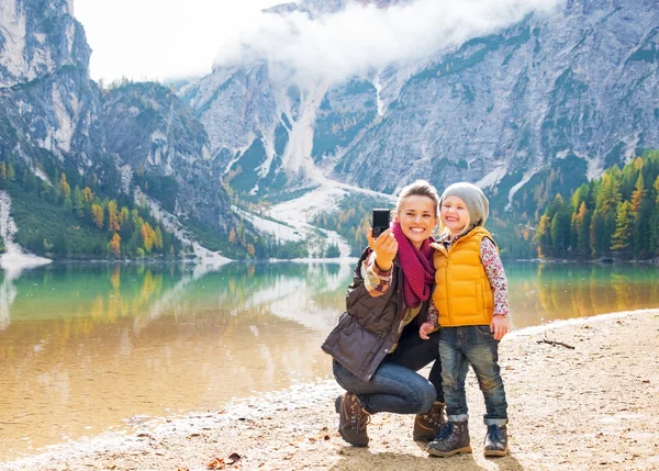 Feliz madre y el bebé tomando auto foto en braies lago en el sur —  Fotos de Stock