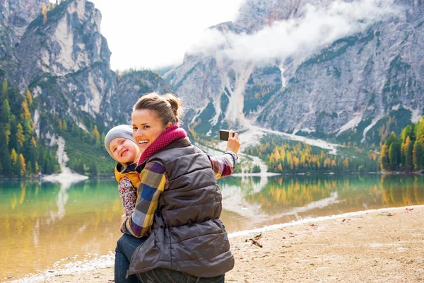 Mãe feliz e bebê tirando foto enquanto em braies lago no sul — Fotografia de Stock