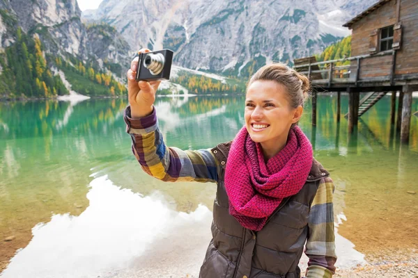 Smiling young woman taking photo on lake braies in south tyrol, — Stock Photo, Image