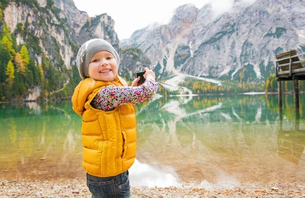 Niño feliz tomando fotos de las braies del lago en el Tirol del Sur, Italia —  Fotos de Stock