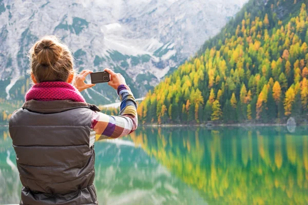 Mladá žena brát fotografie na jezeře braies v Jižní Tyrolsko, Itálie. r — Stock fotografie