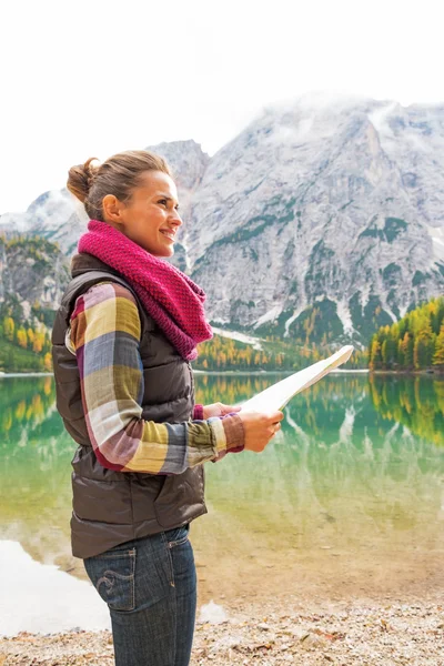 Happy young woman with map on lake braies in south tyrol, italy — Stock Photo, Image