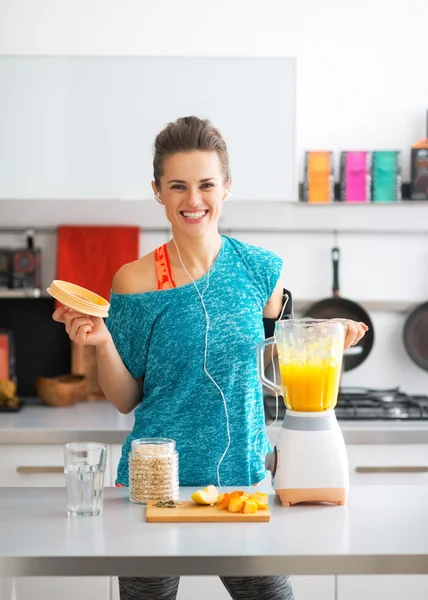 Portrait of happy fitness young woman making pumpkin smoothie in — Stock Photo, Image