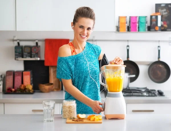 Retrato de feliz fitness joven mujer haciendo batido de calabaza en —  Fotos de Stock