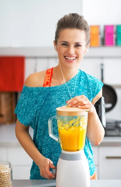 Portrait of happy fitness young woman making pumpkin smoothie in — Stock Photo, Image