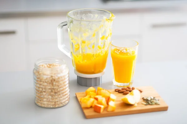 Gros plan sur le smoothie à la citrouille et les ingrédients sur la table dans la cuisine — Photo