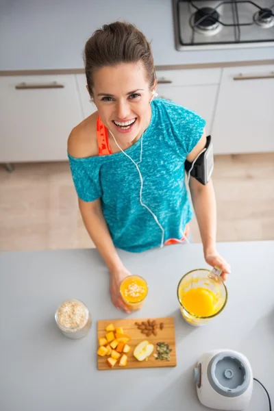 Portrait de jeune femme heureuse fitness faisant smoothie à la citrouille dans — Photo