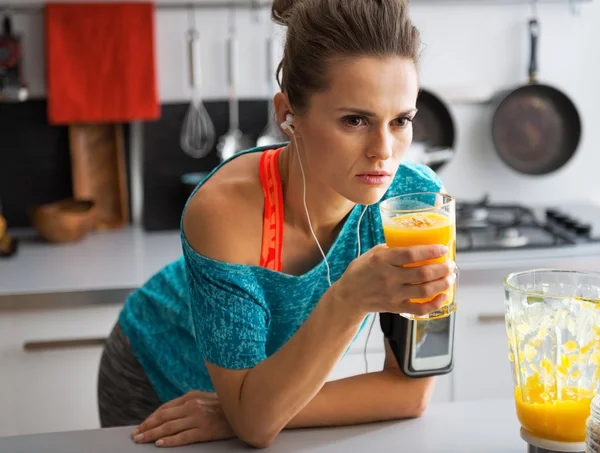 Fitness young woman with glass of pumpkin smoothie in kitchen — Stock Photo, Image