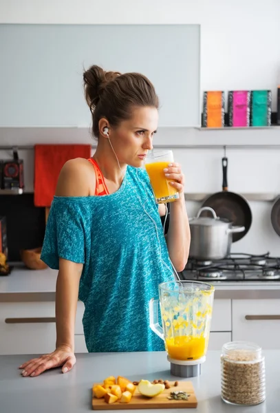 Fitness mladá žena pití dýňová koktejl v kuchyni — Stock fotografie