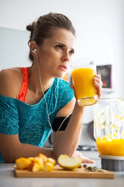 Fitness young woman with glass of pumpkin smoothie in kitchen — Stock Photo, Image