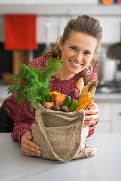 Portret van lachende jonge huisvrouw met groenten van lokale m — Stockfoto