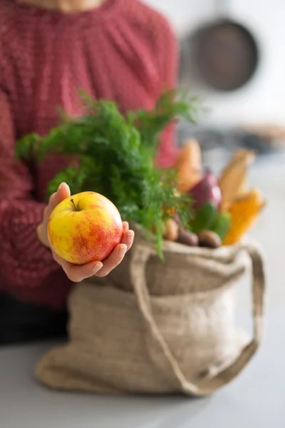 Närbild på ung hemmafru visar apple — Stockfoto