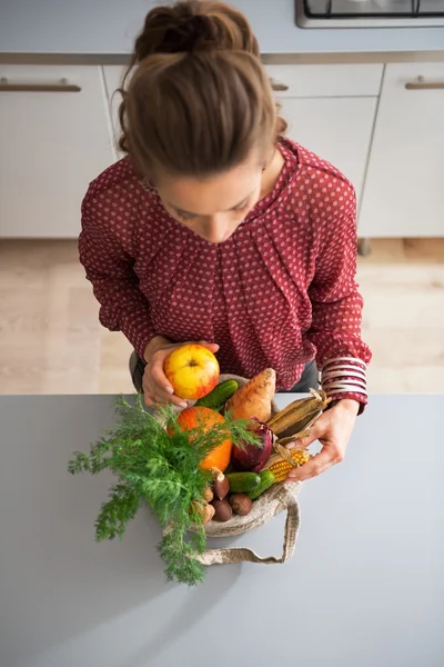 Young housewife sort purchases after shopping on local market — Stock Photo, Image