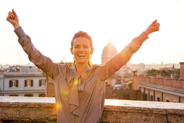 Happy young woman rejoicing on street overlooking rooftops of ro — Stock Photo, Image