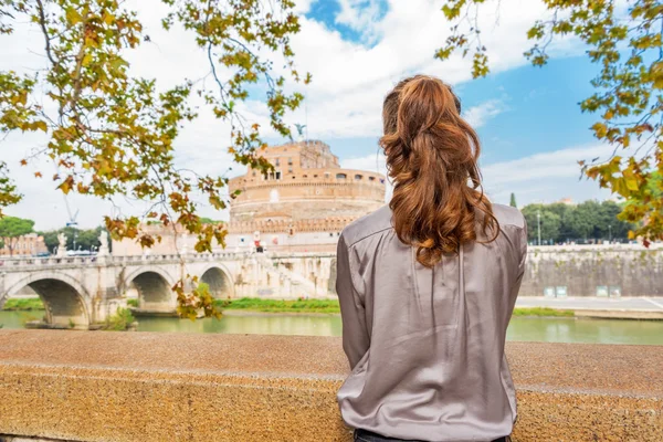 Young woman on embankment looking on castel sant'angelo in rome — Stock Photo, Image