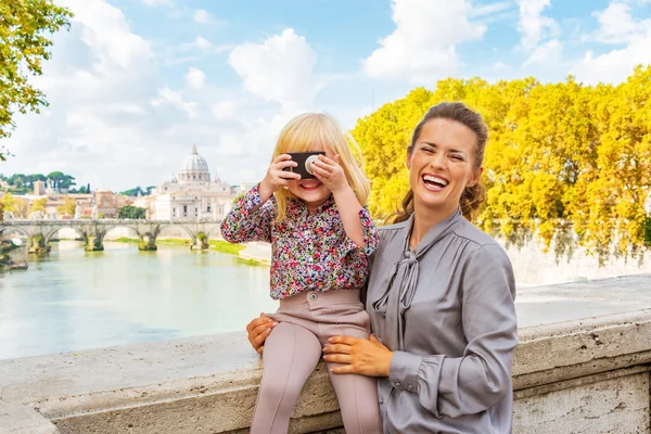 Mãe feliz e bebê menina com câmera de foto na ponte umb — Fotografia de Stock