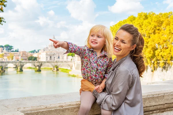 Happy mother and baby girl pointing while on bridge ponte umbert — Stock Photo, Image