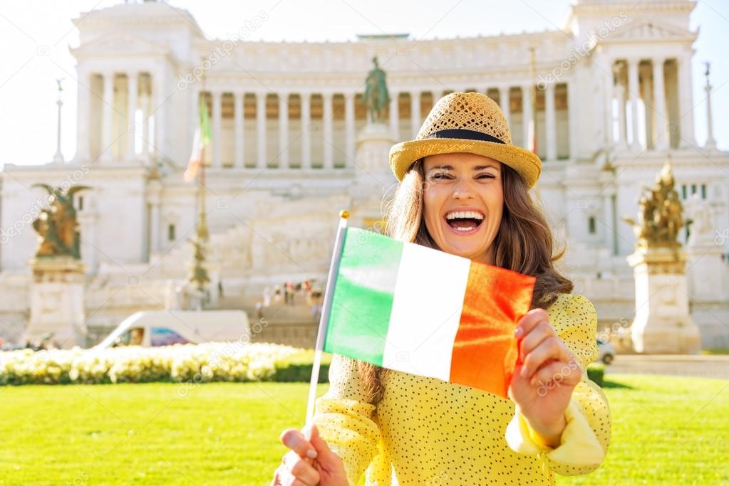 Portrait of happy young woman showing italian flag on piazza ven