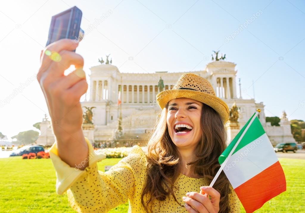 Happy young woman with italian flag making selfie on piazza vene