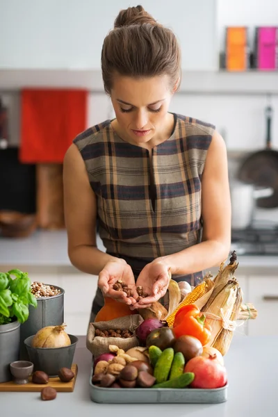 Jonge huisvrouw met groenten in de keuken — Stockfoto